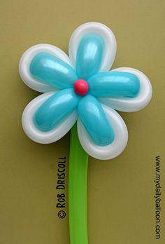 a flower shaped balloon on top of a green toothbrush