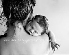 a black and white photo of a woman holding a baby in her arms, with the child's head resting on her shoulder