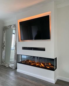 a flat screen tv mounted to the side of a wall next to a fire place