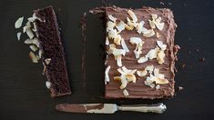 a piece of chocolate cake sitting on top of a wooden table next to a knife