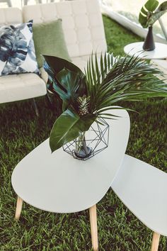 two tables with plants on them sitting in the grass