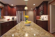 a large kitchen with granite counter tops and wooden cabinets, along with stainless steel appliances