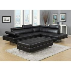 a black leather sectional sofa sitting on top of a white rug in a living room