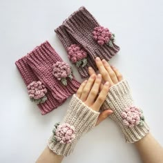 two hands with knitted mittens and flowers on them