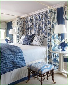 a bedroom with blue and white decor on the walls, curtains, and bedding