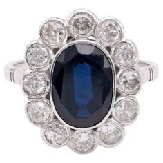 Center Stone: Sapphire Cut: Oval Weight: Approximately 2.9 Carats Color: Deep Blue Accent Stone: 12 Diamonds Cut: Old European Weight: Approximately 1.6 Carats Color: G Clarity: SI Metal: Platinum Era: Edwardian Circa: 1910s Hallmarks: Makers Marks Size: 8 and can be resized Gram weight: 5.53 This exquisite Edwardian ring from the 1910s is a stunning example of vintage elegance and craftsmanship. Crafted in luxurious platinum, the ring features a captivating oval cut deep blue sapphire at its center, weighing approximately 2.9 carats. Surrounding the sapphire are twelve dazzling old European cut diamonds, with a total weight of approximately 1.6 carats. These diamonds, with their G color and SI clarity, add a brilliant sparkle to the piece. The ring is marked with maker's marks, ensuring i Edwardian Ring, Blue Accent, Vintage Elegance, European Cut Diamonds, Elegant Ring, Blue Accents, Sapphire Diamond, Cluster Ring, Makers Mark