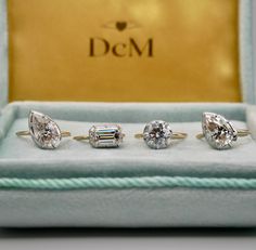 three diamond engagement rings in a box