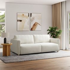 a white couch sitting on top of a hard wood floor next to a wooden table