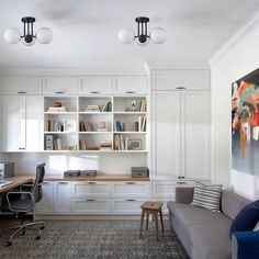 a living room filled with furniture and bookshelves next to a painting on the wall