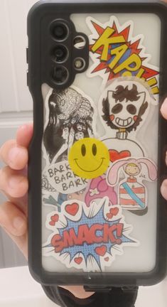 someone is holding up their phone case with stickers on it