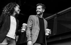 black and white photo of two people holding coffees in their hands - stock photo - images