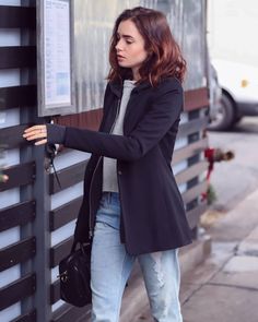 a woman leaning against a wall with her hand on the door