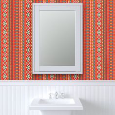 a white sink sitting under a bathroom mirror next to a wall mounted faucet