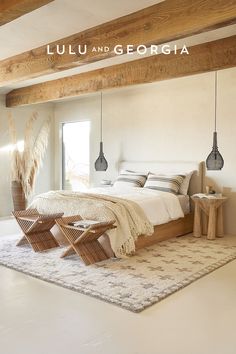 a bedroom with white walls and wooden beams