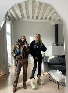 a man and woman are standing in the living room taking a photo with their camera