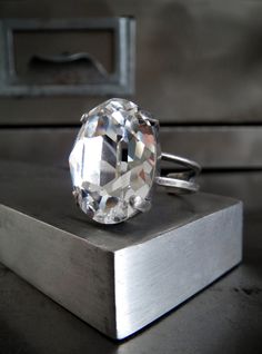 "Stunningly sparkly, crystal-clear, oval-shaped crystal cocktail ring with the unsurpassed faceting & depth of Swarovski crystal. This classic, timeless shape paired is with a modern + minimalist antiqued silver bezel on an adjustable twin-ring band, which fits approx. sizes 6 to 9. - Clear oval Swarovski crystal: 13 x18 mm (approx. 1/2\" x 3/4\") - Ring is adjustable to fit approx. sizes 6 to 9 See all the amazing crystal rings in the Shy Siren shop: https://www.etsy.com/shop/ShySiren/searc Elegant Oval Crystal Ring For Parties, Classic Crystal Ring, Classic Crystal Ring With Prong Setting For Party, Silver Faceted Oval Crystal Ring, Classic Sparkling Crystal Ring, Formal Faceted Oval Crystal Ring, Formal Oval Faceted Crystal Ring, Silver Oval Crystal Ring For Party, Formal Oval Clear Rings