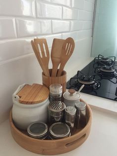 wooden utensils and spoons are in a tray on the counter