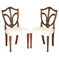 a pair of wooden chairs with white upholstered back and seat cushions on each side