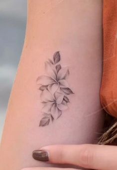 a woman's arm with a flower tattoo on the left side of her body