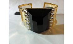 "Gold tone cuff bracelet with faux black onyx stone and rhinestone embellishments. NOS with store tag attached. Dramatic and unusual combination of mesh and black. From the estate of a sales rep for this company. - measurements - 1 1/4\" wide - 6 1/2\" - 7 1/2 from end to end on the outside - hallmark - hang tag: Fifth Avenue Collection - \"Well Armed\" - 7\" - $39.99 - condition - Unworn with store tag attached." Modern Black Cuff Bracelet For Parties, Black Jeweled Evening Jewelry, Formal Black Jeweled Jewelry, Black Jeweled Jewelry For Evening, Luxury Black Metal Cuff Bracelet, Elegant Black Metal Cuff Bracelet, Elegant Black Bracelets With Bling, Elegant Black Cuff Bracelet For Party, Elegant Black Cuff Bracelet For Evening