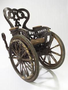 an old fashioned wheelchair is on display against a white background with the wheels still attached