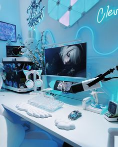 a desk with a computer monitor, keyboard and mouse on it in front of a neon blue wall