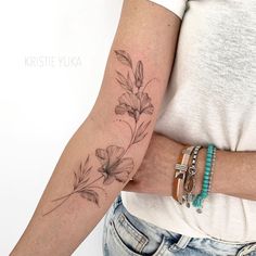 a woman's arm with a flower tattoo on the left side of her arm