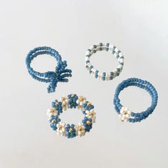 three bracelets and two rings with pearls on them