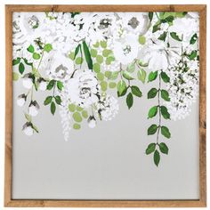 white flowers and green leaves are hanging on the wall