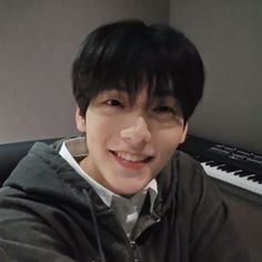 a young man sitting in front of a piano