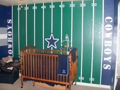 a baby crib in front of a football themed wall