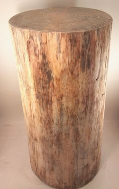 a wooden stool made out of logs on a white surface with no one around it