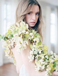 a woman holding flowers in her arms