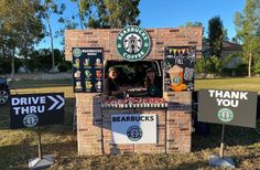 two people are sitting in the driver's seat of a brick starbucks truck decorated with signs