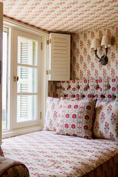 a bed room with a neatly made bed and two lamps