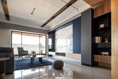 a modern living room with black and white decor on the walls, carpeted flooring and large windows