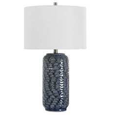 a blue table lamp with a white shade on the top and an ocean wave design