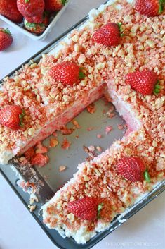 there is a cake with strawberries on the top and one slice missing from it