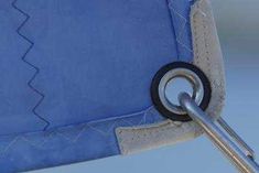 a close up of a blue chair with a metal hook on it's side