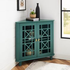 a living room with a green cabinet and potted plants