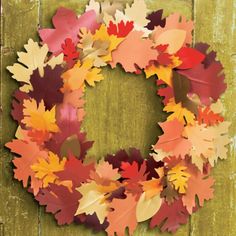 a wreath made out of autumn leaves on a wooden background with text overlay that says fall crafts for kids