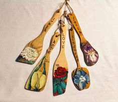 four wooden spoons with flowers painted on them