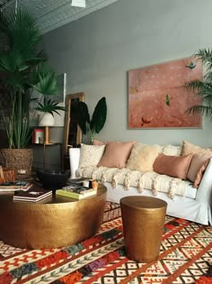 a living room filled with lots of furniture and plants on top of a colorful rug