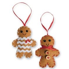 two gingerbread christmas ornaments hanging from red ribbon