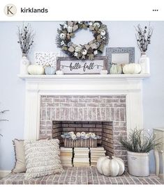 the fireplace is decorated with white pumpkins and greenery on it's mantle