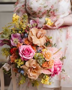 a woman holding a bouquet of flowers in her hands