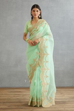 Green saree with dori, sequin embroidery in floral pattern on scallop border.
Components: 1
Pattern: Embroidery
Type Of Work: Dori, sequin, floral
Fabric: Silk Organza, Cotton Silk
Color: Green
Other Details: 
Note: Blouse worn by the model is not for sale
Occasion: Wedding - Aza Fashions Torani Saree, Dori Embroidery, Scallop Border, Border Saree, Embroidered Saree, Green Saree, Indian Fashion Designers, Sequins Embroidery, Designer Saree