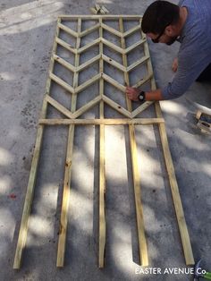 a man is working on some kind of wood structure that's being built into the ground