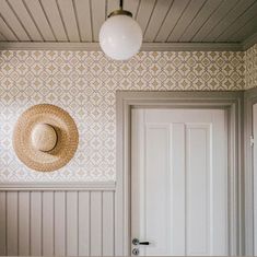 a hat is hanging on the wall next to a door with a light above it