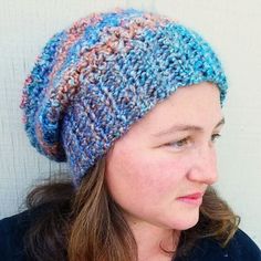 a close up of a person wearing a knitted hat and looking off to the side